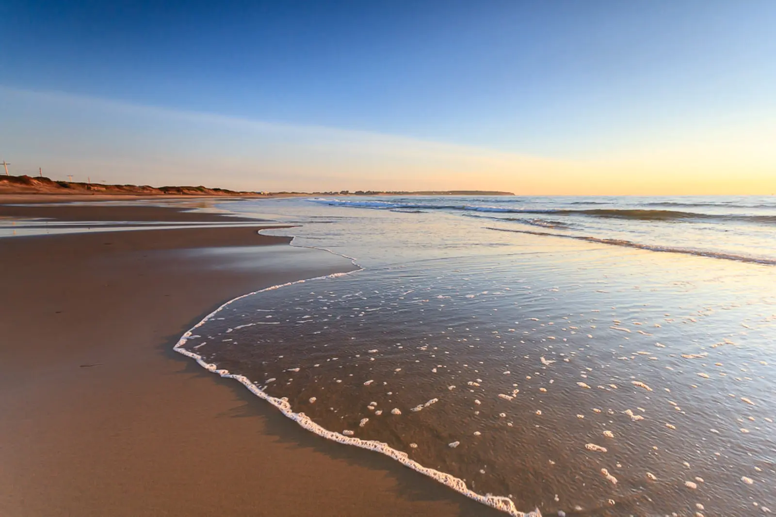 A powerful wave crashing along Block Island’s shore under a glowing sky, capturing motion and energy.
