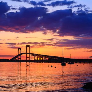 The Newport Bridge under dramatic, colorful skies at sunset, inspiring awe, reflection, and calm.